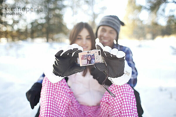 Paar nimmt Selfie im verschneiten Wald