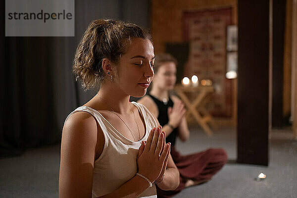 Glückliche Frau beim Meditieren während einer Yoga-Sitzung
