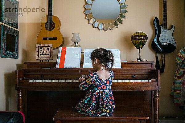 Mädchen spielt Klavier  süßes Kind im Vorschulalter übt Musikinstrument