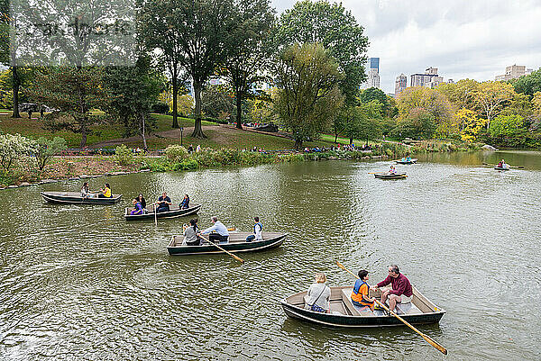 Eine Gruppe von Menschen rudert in kleinen Booten auf dem See im Central Park