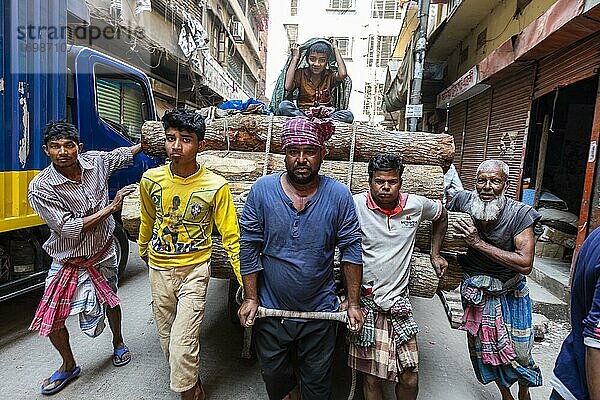 Männer tragen eine große Last durch den Basar  Dhaka  Bangladesch  Asien