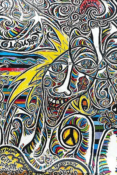 Graffiti Wir sind ein Volk  Wandgemälde mit buntem lachenden Gesicht und Peace Symbol  Künstler Schamil Gimajew  East Side Gallery  Friedrichshain  Berlin  Deutschland  Europa