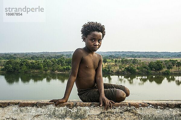 Einheimischer Junge sitzt am Fluss  Massangano  Cuanza Norte  Angola  Afrika