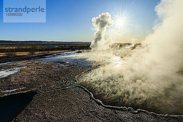 Heiße Quelle  hinten Eruption des Geysir Strokkur  Geothermalgebiet Haukadalur  Golden Circle  Südisland  Island  Europa