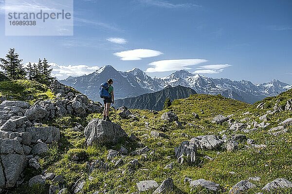 Wanderin steht auf Felsen und blickt auf Berge  Schynige Platte  hinten Berggipfel  Jungfrauregion  Grindelwald  Kanton Bern  Schweiz  Europa