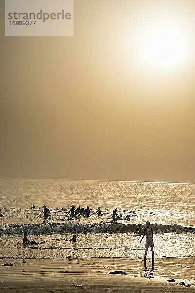 Menschen baden am Strand von Lumley bei Sonnenuntergang  Freetown  Sierra Leone  Afrika