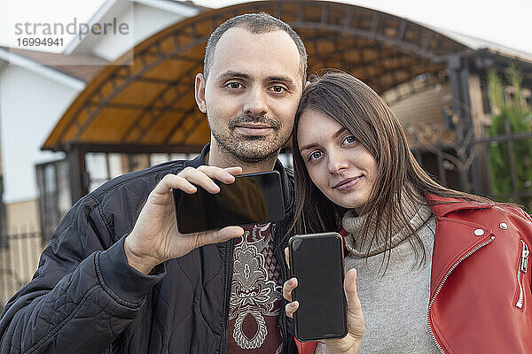 Porträt junges Paar mit Kamera-Handys