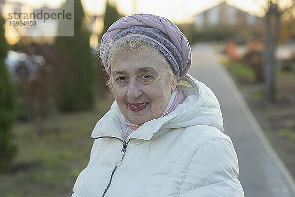 Porträt glücklich schöne ältere Frau im Wintermantel auf dem Bürgersteig