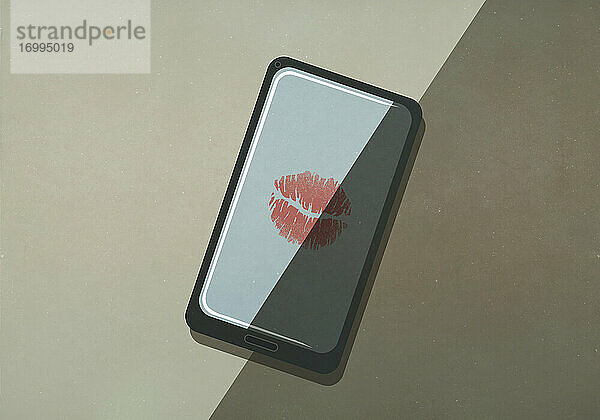 Lippenstiftkuss auf Smartphone-Bildschirm