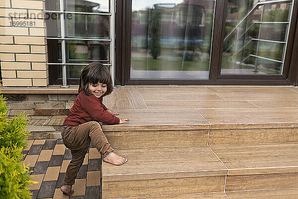 Nette barfuß Kleinkind Junge klettern Terrasse Schritte