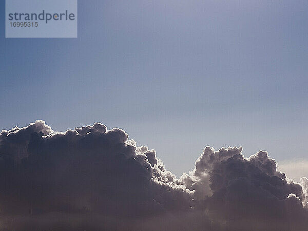 Flauschige Kumuluswolken am sonnigen blauen Himmel