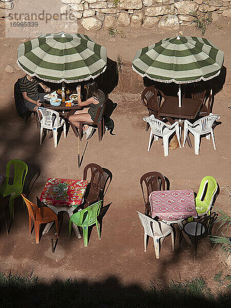 Menschen speisen unter Regenschirm bei sonnigen Café  Paradise Valley  Marokko