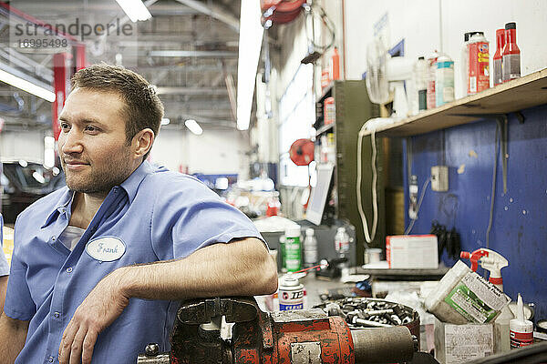Porträt eines lächelnden kaukasischen männlichen Mechanikers in einer Autowerkstatt