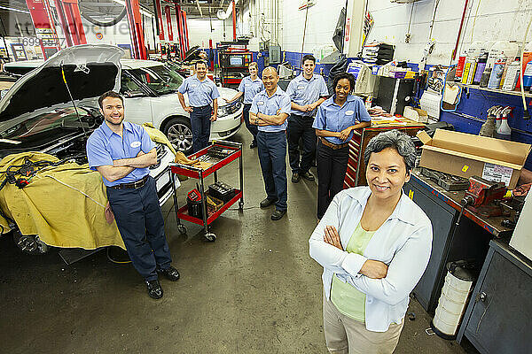 Porträt eines Teams von Mechanikern in einer Autowerkstatt von oben gesehen