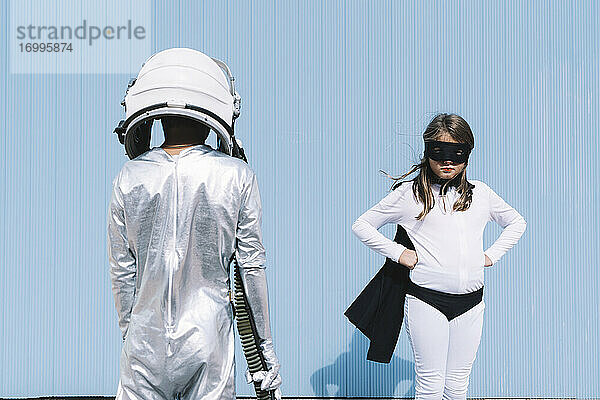 Zwei Kinder in Astronauten- und Superheldenkostümen