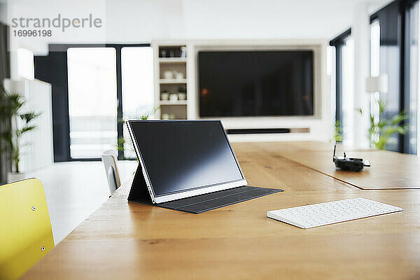 Digitales Tablet und weiße Tastatur auf dem Tisch im Heimbüro