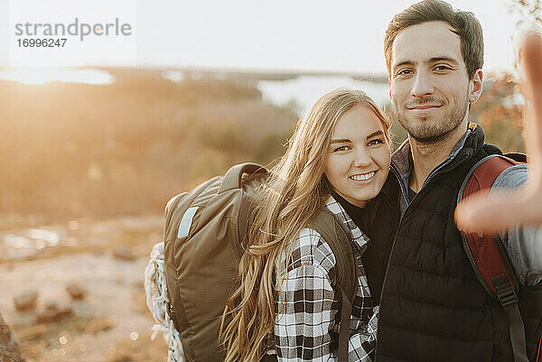 Porträt eines jungen Paares  das während einer Herbstwanderung zusammen posiert