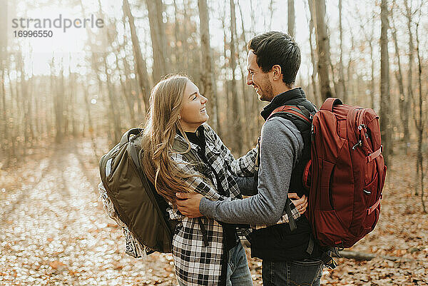 Junges Paar  das sich bei einer Herbstwanderung im Wald umarmt