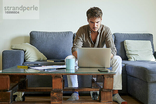 Geschäftsmann konzentriert sich bei der Arbeit am Laptop zu Hause