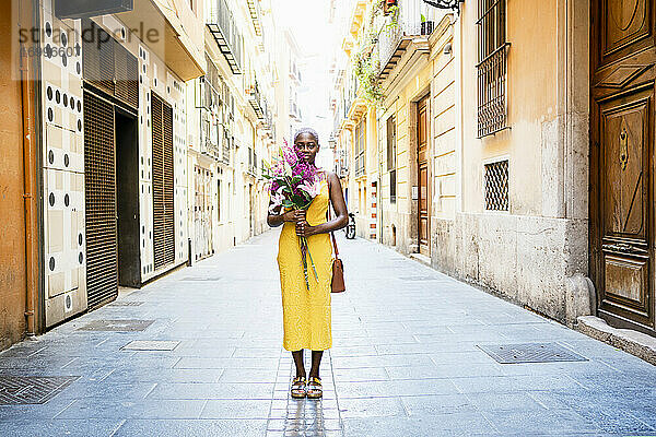 Frau mit leerem Blick hält Blumen auf der Straße in der Stadt