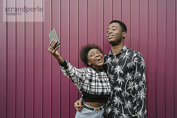 Porträt eines jungen Paares  das ein Selfie mit einem Smartphone macht