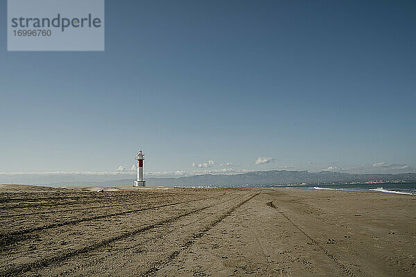 Klarer Himmel über leeren Platja del Fangar Strand mit Far del Fangar Leuchtturm im Hintergrund
