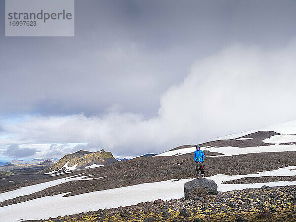 Männlicher Wanderer steht auf einem Felsen im Snaefellsjokull Nationalpark  Island