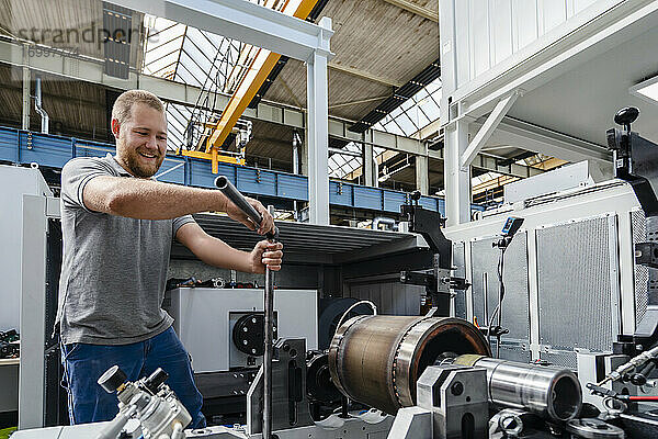 Handwerker lächelnd bei der Arbeit in einer Fabrik