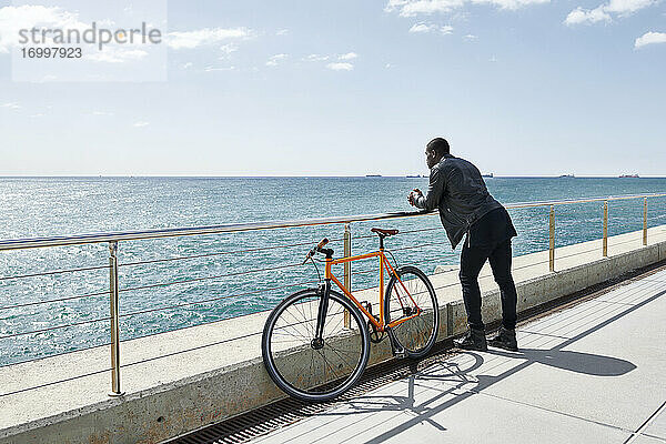 Mann mit Fahrrad auf der Uferpromenade