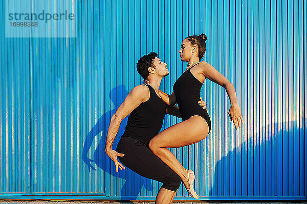 Professionelle Turner Paar tun Balancieren Pose von blauen Wellblech