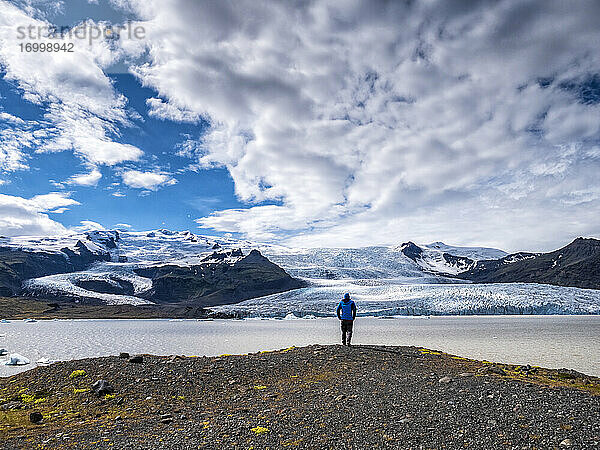 Mann betrachtet die Aussicht vom Berg gegen den bewölkten Himmel am Breidamerkurjokull  Island