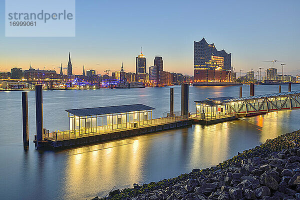 Deutschland  Hamburg  Nördliches Elbufer in der Morgendämmerung mit Elbphilharmonie und Stadtsilhouette im Hintergrund