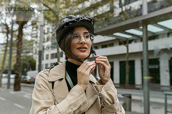 Frau mit Fahrradhelm auf der Straße in der Stadt