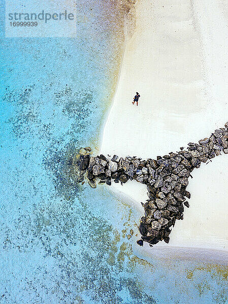 Malediven  Kaafu Atoll  Luftaufnahme eines Mannes  der allein am Sandstrand der Insel Huraa spazieren geht
