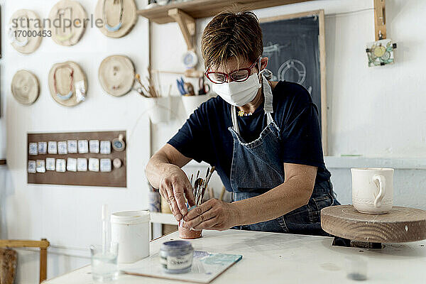 Künstlerin bei der Arbeit in der Keramikwerkstatt während der COVID-19