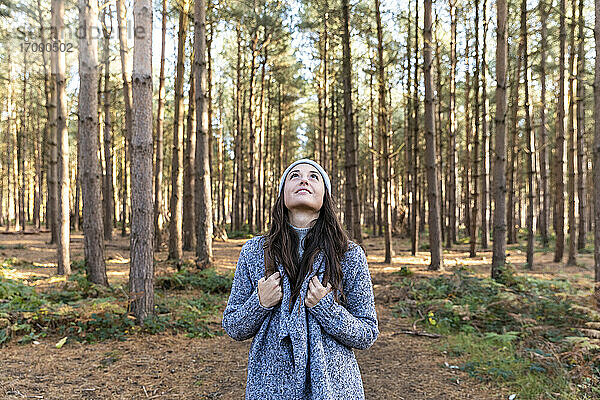 Mid adult woman looking up while exploring in Cannock Chase forest