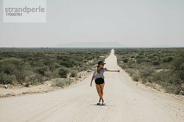 Namibia  Frau  die auf der Straße zur Spitzkoppe trampt