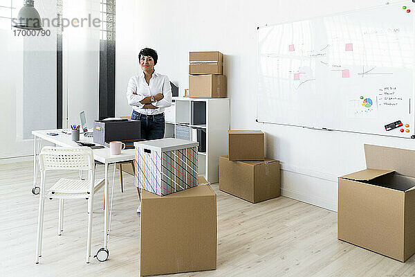 Porträt einer Geschäftsfrau  die in einem mit Kartons gefüllten Büro steht