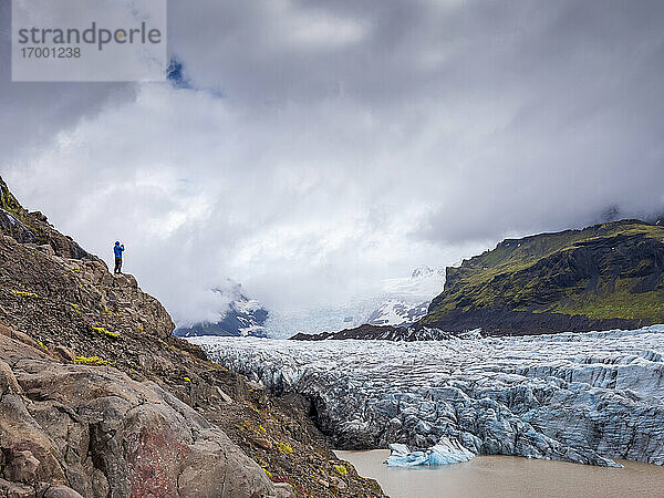 Mann steht auf einem Berg vor bewölktem Himmel am Svinafellsjokull-Gletscher  Island