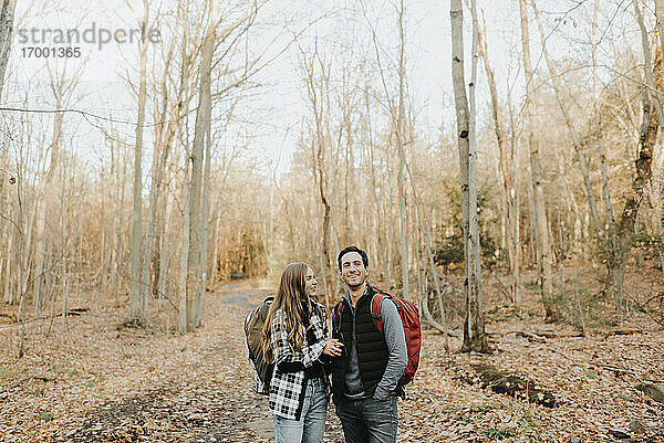Junges Paar unterhält sich bei einer Herbstwanderung im Wald