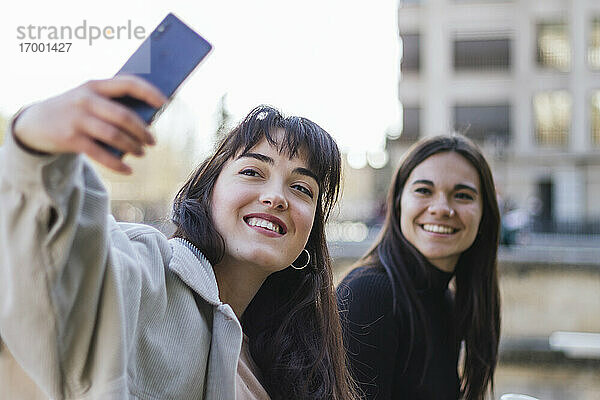 Glückliche junge Frau nimmt Selfie weiblichen Freund beim Sightseeing