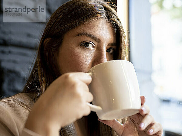 Frau starrt beim Kaffeetrinken im Café