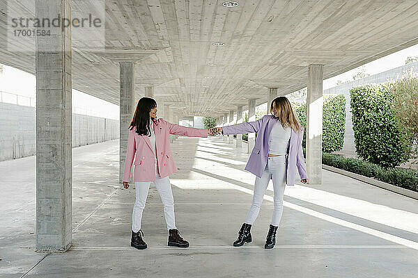 Junge Schwestern halten sich auf einem Parkplatz an den Händen