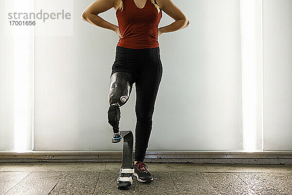 Sportler mit Beinprothese steht in einer Unterführung an der Wand