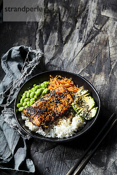 Schüssel mit Teriyaki-Lachs mit Reis  Karottensalat  Edamame-Bohnen  Avocado und Sesam