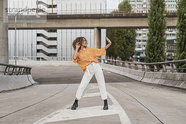 Frau tanzt auf einer Brücke in der Stadt