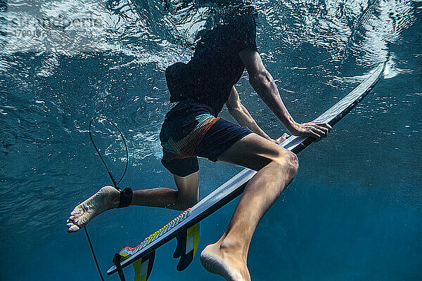 Männlicher Surfer genießt Unterwasser-Surfen im Meer auf den Malediven
