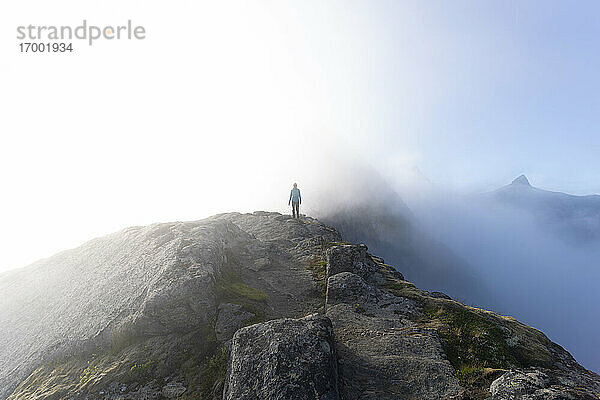 Wanderer auf einem Berg am Helvetestinden  Lofoten  Norwegen