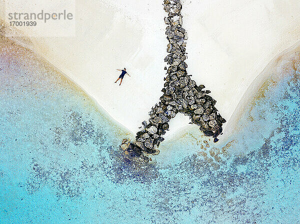 Malediven  Kaafu Atoll  Luftaufnahme eines Mannes  der allein am Sandstrand der Insel Huraa liegt