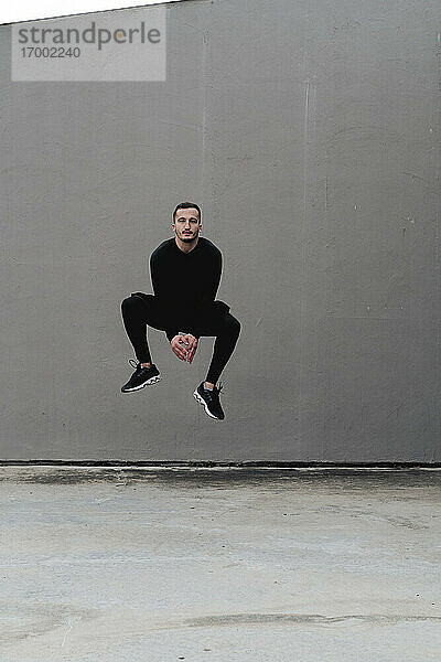 Junger Mann springt gegen die Wand